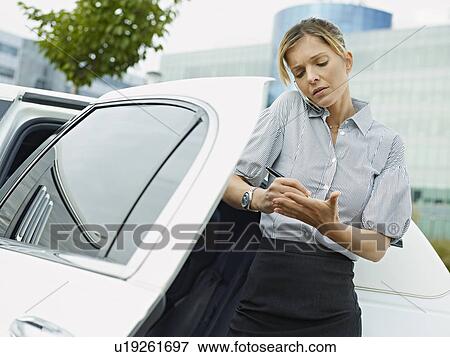 Businesswoman in limo take notes on hand View Large Photo Image Stock Photo - Businesswoman in limo take notes on hand. Fotosearch