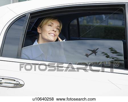 Stock Photo - Businesswoman in limousine at airport. Fotosearch
