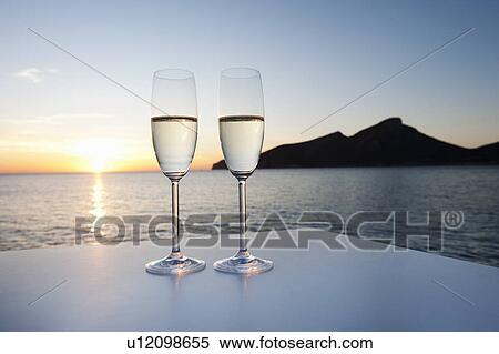 Stock Photography - Champagne glasses shot against a sunset. Fotosearch
