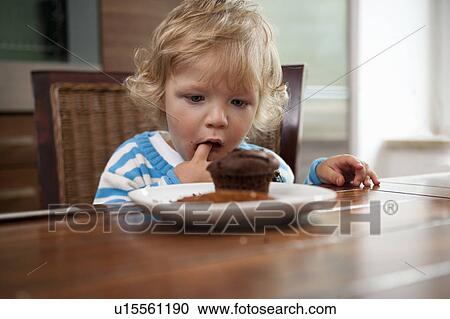 Child looking at muffin View Large Photo Image Stock Image - Child looking at muffin. Fotosearch