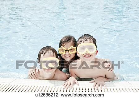 Stock Image - Children in pool wearing swimming goggle. Fotosearch