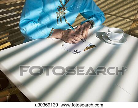 Close up of woman writing postcard View Large Photo Image Stock Photo - Close up of woman writing postcard. Fotosearch