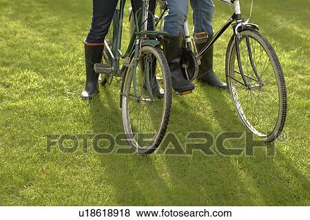 Close-up, two people+ old bicycles grass View Large Photo Image Stock Photo - Close-up, two people+ old bicycles grass. Fotosearch