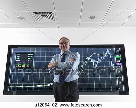 Stock Image - Company director in front of screen. Fotosearch