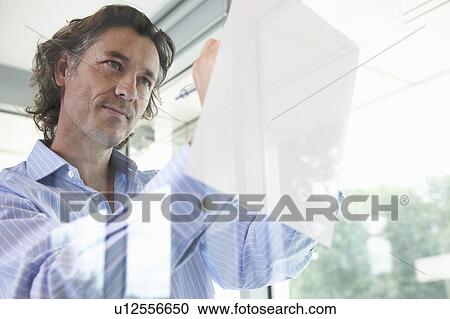 Confident man writing, leaning on window View Large Photo Image Stock Image - Confident man writing, leaning on window. Fotosearch