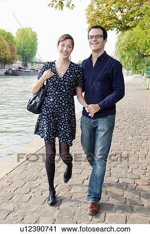 Stock Image -  couple arm in arm by the Seine Paris. Fotosearch