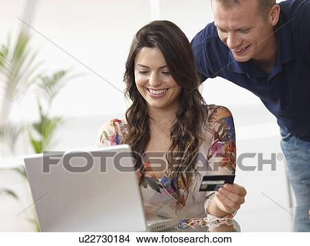 Picture - Couple at home shopping online. Fotosearch