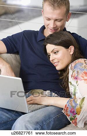 Stock Image - Couple at home shopping online. Fotosearch