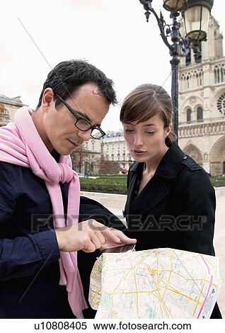 Stock Photography - Couple check map in Paris. Fotosearch