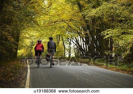 Stock Photo - Couple cycling down country road. Fotosearch