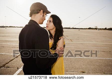 Couple embracing in parking lot View Large Photo Image Stock Photo - Couple embracing in parking lot. Fotosearch