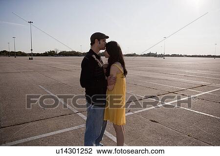 Couple embracing in the parking lot View Large Photo Image Stock Image - Couple embracing in the parking lot. Fotosearch