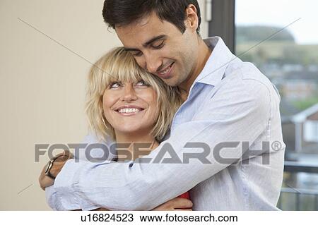 Couple hugging in their new apartment View Large Photo Image Stock Image - Couple hugging in their new apartment. Fotosearch