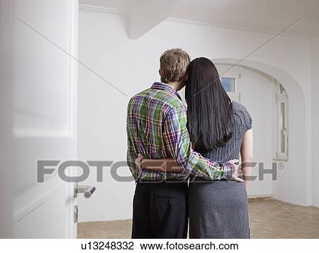 Stock Image - Couple in embracing in empty flat. Fotosearch