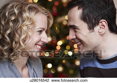 Couple in front of xmas tree View Large Photo Image Stock Image - Couple in front of xmas tree. Fotosearch