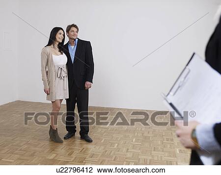 Couple is viewing flat with estate agent View Large Photo Image Stock Image - Couple is viewing flat with estate agent. Fotosearch