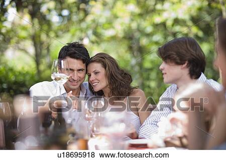 Couple looking at a glass of wine View Large Photo Image Stock Photo - Couple looking at a glass of wine. Fotosearch