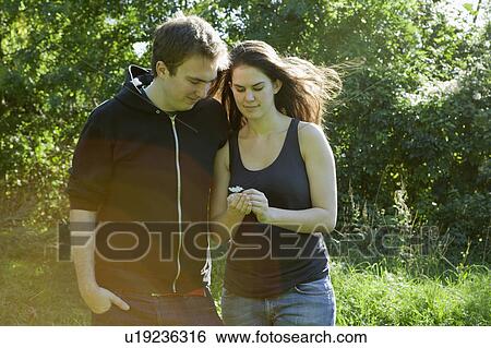 Couple looking at flower View Large Photo Image Stock Photograph - Couple looking at flower. Fotosearch