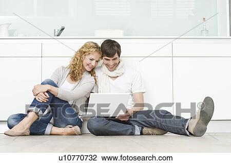 Couple looking into laptop View Large Photo Image Stock Image - Couple looking into laptop. Fotosearch