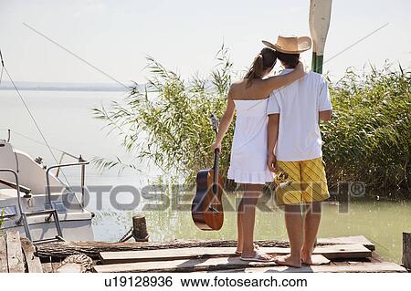 Couple looking out over lake View Large Photo Image Stock Photograph - Couple looking out over lake. Fotosearch