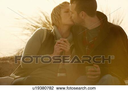 Couple outdoors kissing. With coffee View Large Photo Image Stock Image - Couple outdoors kissing. With coffee. Fotosearch