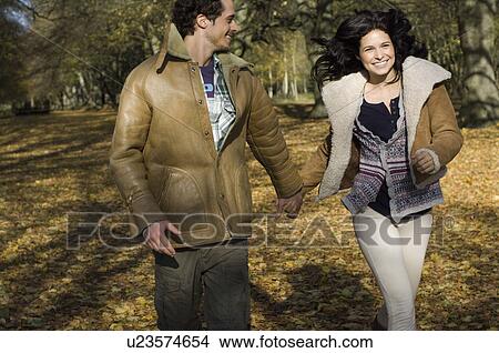 Couple running hand in hand View Large Photo Image Picture - Couple running hand in hand. Fotosearch
