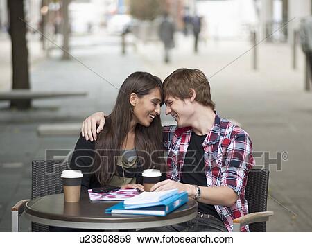 Couple seated at cafe table, embracing View Large Photo Image Stock Photo - Couple seated at cafe table, embracing. Fotosearch