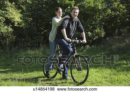 Couple sharing bicycle View Large Photo Image Stock Photo - Couple sharing bicycle. Fotosearch