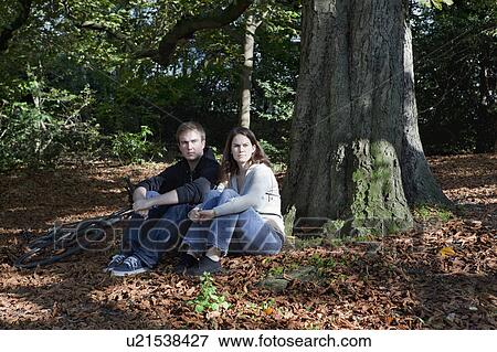 Couple sitting in forest View Large Photo Image Stock Photo - Couple sitting in forest. Fotosearch