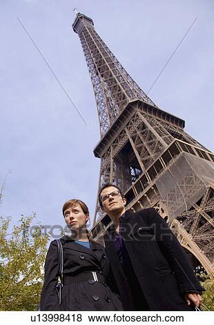 Stock Photo - Couple stand by Eiffel tower Paris. Fotosearch