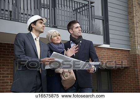 Stock Photography - Couple talking to architect. Fotosearch