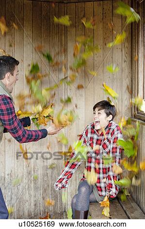 Couple throwing leaves and laughing View Large Photo Image Stock Photo - Couple throwing leaves and laughing. Fotosearch