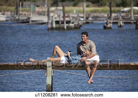 Stock Image - Couple together on dock. Fotosearch