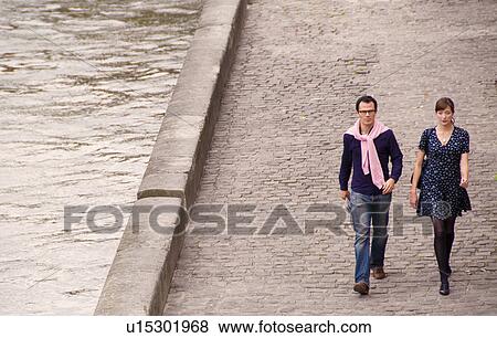 Couple walk beside the Seine Paris View Large Photo Image Stock Photo - Couple walk beside the Seine Paris. Fotosearch