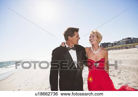 Stock Photograph - Couple walking on a beach. Fotosearch