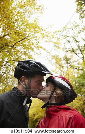 Couple wearing cycle helmets kissing View Large Photo Image Picture - Couple wearing cycle helmets kissing. Fotosearch