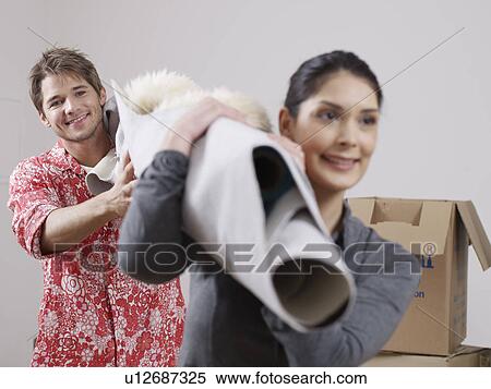 Stock Photography - Couple with carpet over their shoulders. Fotosearch