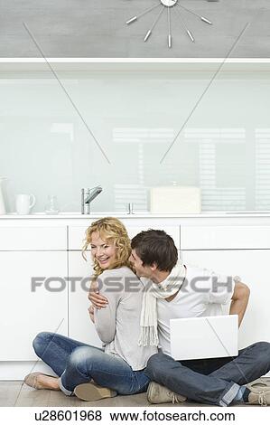 Couple with laptop on kitchen floor View Large Photo Image Stock Photo - Couple with laptop on kitchen floor. Fotosearch
