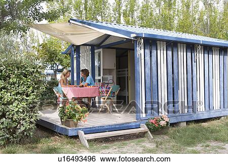 Stock Photograph - Cple talk on cabin terrace with pie. Fotosearch