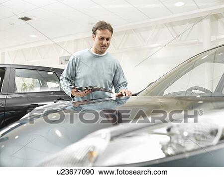 Customer looks at car in car dealership View Large Photo Image Stock Image - Customer looks at car in car dealership. Fotosearch