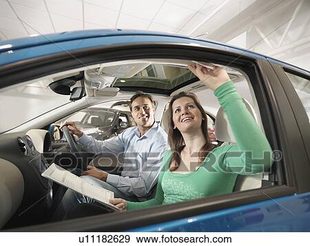 Stock Photo - Customers look at car interior. Fotosearch