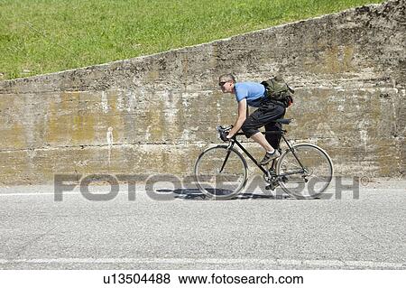 Stock Photo - Cyclist pedaling uphill. Fotosearch