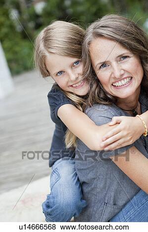 Stock Photo - Daugther hugging mother outside. Fotosearch