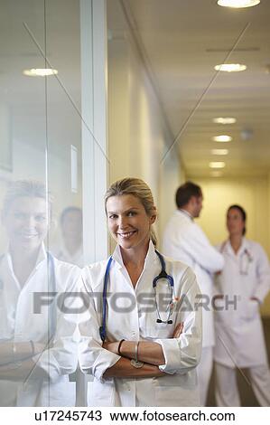 Doctor against a window, smiling View Large Photo Image Stock Image - Doctor against a window, smiling. Fotosearch
