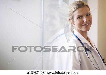 Doctor against a window, smiling View Large Photo Image Stock Photo - Doctor against a window, smiling. Fotosearch