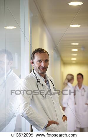 Doctor against a window, smiling View Large Photo Image Stock Photography - Doctor against a window, smiling. Fotosearch