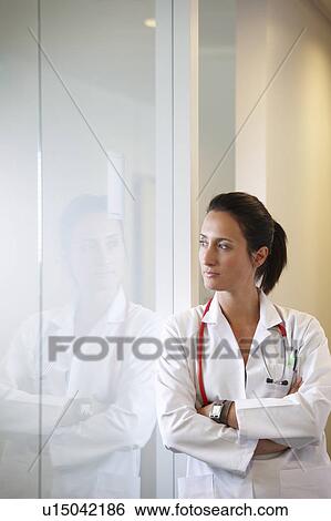 Doctor against a window, thinking View Large Photo Image Stock Photograph - Doctor against a window, thinking. Fotosearch