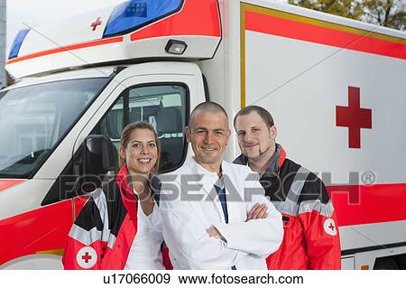 Stock Photo - Doctor and paramedics in front of coach. Fotosearch