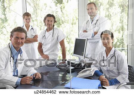 Stock Image - Doctors meeting to discuss files. Fotosearch