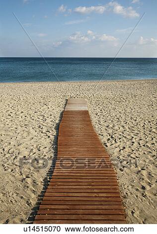 Stock Image - Empty boardwalk running down to sea. Fotosearch
